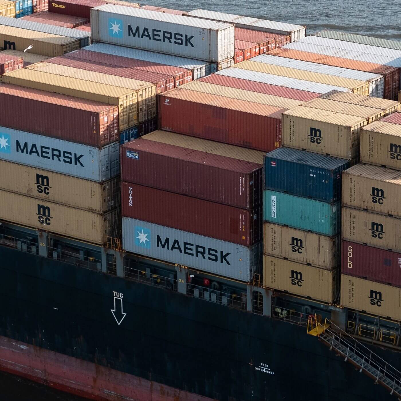 A large industrial boat carrying many shipping containers.